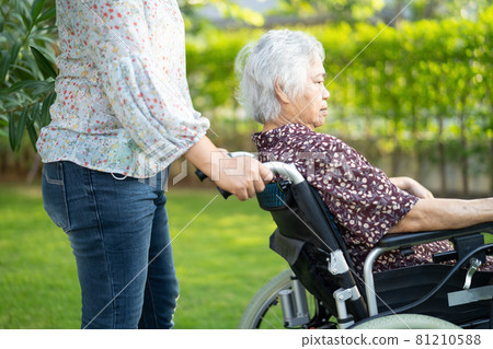 Doctor help and care Asian senior or elderly old lady woman patient sitting on wheelchair at park in nursing hospital ward, healthy strong medical concept. 81210588