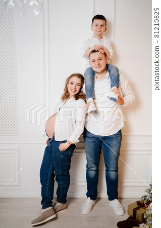 happy family. pregnant mother with her son and father in jeans and a white shirt 81210825