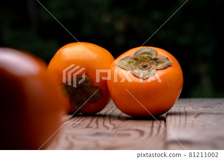 A photo of a persimmon on a wooden board A photo of a persimmon on a wooden board 81211002
