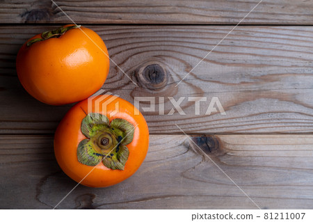 A photo of a persimmon on a wooden board 81211007