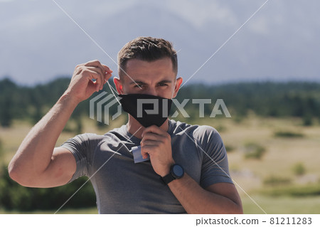 Young man and woman in protective masks running and doing exercises outdoors in the morning. Sport, Active life Jogging during quarantine. Covid-19 new normal. High quality photo. Selective focus. Young man and woman in protective masks running and doing exercises outdoors in the morning. Sport, Active life Jogging during quarantine. Covid-19 new normal. High quality photo. Selective focus. 81211283