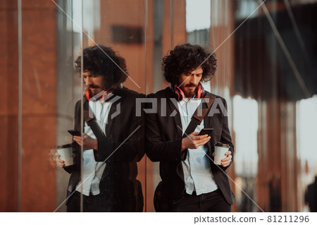 Happy young American holding a coffee. With headphones. Student boy. 81211296