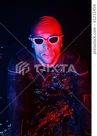 authentic triathlete swimmer having a break during hard training on night neon gel light 81211459