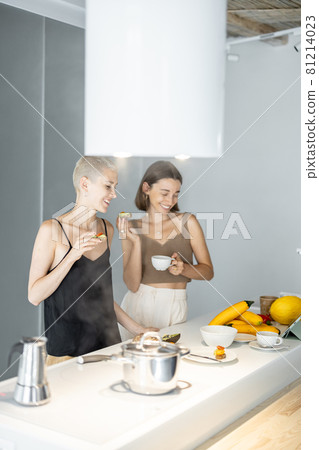 Lesbian couple eating breakfast at kitchen 81214023