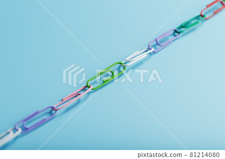 A chain of multi-colored paper clips on a blue background 81214080