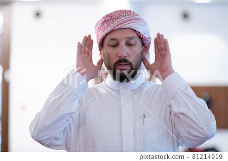 a Muslim begins to offer prayer by raising his hands in the air, a calm state in prayer. a Muslim begins to offer prayer by raising his hands in the air, a calm state in prayer. 81214919