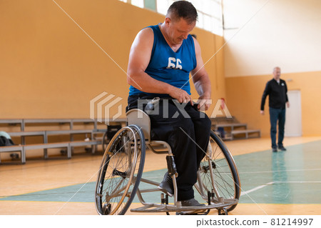 a handicapped basketball player prepares for a match while sitting in a wheelchair.preparations for a professional basketball match. the concept of disability sport 81214997