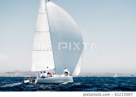 Sport boat with a white sail on regatta, rear view Sport boat with a white sail on regatta, rear view 81215007