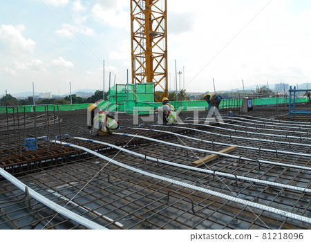 MALACCA, MALAYSIA -APRIL 14, 2016: Pre-stress cable laid in round ducting install in between the slab steel reinforcement bar at the construction site. Installed by workers. MALACCA, MALAYSIA -APRIL 14, 2016: Pre-stress cable laid in round ducting install in between the slab steel reinforcement bar at the construction site. Installed by workers. 81218096