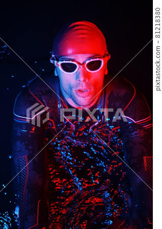 authentic triathlete swimmer having a break during hard training on night neon gel light authentic triathlete swimmer having a break during hard training on night neon gel light 81218380