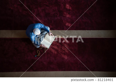 muslim man praying Allah alone inside the mosque and reading islamic holly book muslim man praying Allah alone inside the mosque and reading islamic holly book 81218401