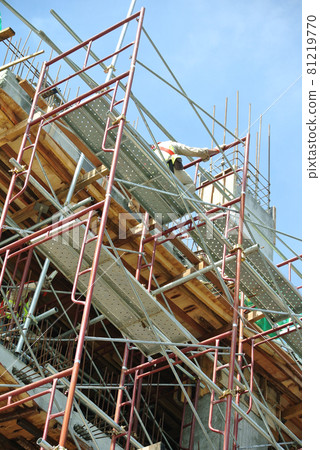SEREMBAN, MALAYSIA -AUGUST 05, 2016: Construction workers wearing safety harness and adequate safety gear while working at high level at the construction site in Seremban, Malaysia. SEREMBAN, MALAYSIA -AUGUST 05, 2016: Construction workers wearing safety harness and adequate safety gear while working at high level at the construction site in Seremban, Malaysia. 81219770