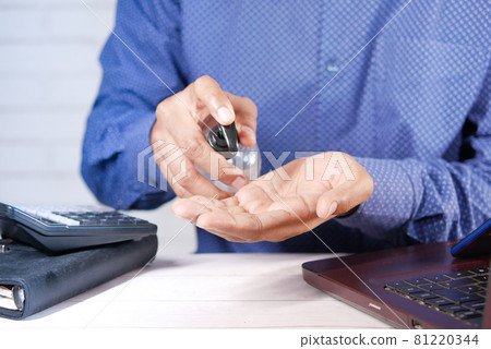 businessman applying sanitizer liquid before using laptop  81220344