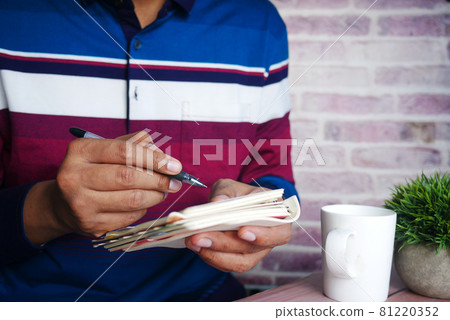 Close up of man hand writing on notepad. 81220352