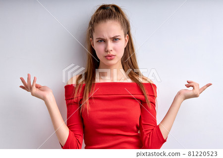 Photo portrait of misunderstanding girl displeased unhappy in redh shirt isolated 81220523