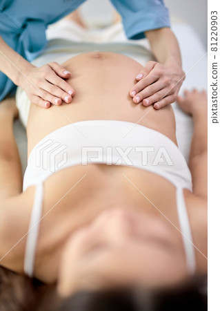 Young pregnant woman receiving tummy belly massage in spa center Young pregnant woman receiving tummy belly massage in spa center 81220903