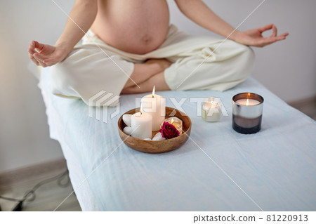 Cropped young pregnant woman sitting in yoga position in spa room, relaxing Cropped young pregnant woman sitting in yoga position in spa room, relaxing 81220913