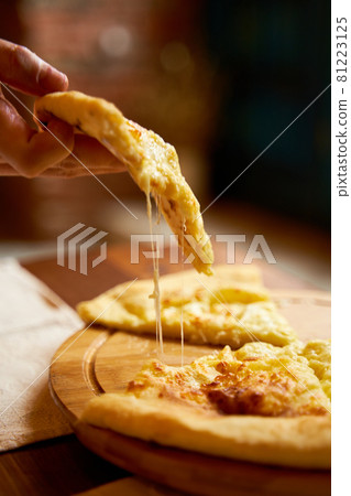 Hot khachapuri in Imeretian style. Stretching processed cheese. Incredibly delicious dish 81223125