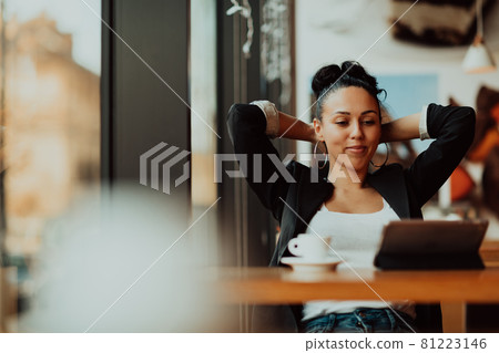 a latino woman sitting in a cafe on a break from work a latino woman sitting in a cafe on a break from work 81223146