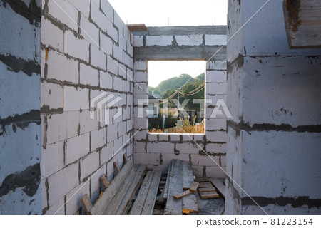 Inside view. House under construction, box of a house without a roof. View from the window. Wall erection stage Inside view. House under construction, box of a house without a roof. View from the window. Wall erection stage 81223154