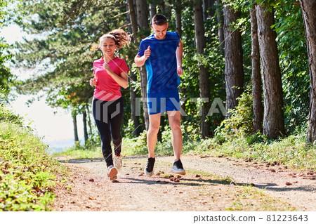 couple enjoying in a healthy lifestyle while jogging on a country road couple enjoying in a healthy lifestyle while jogging on a country road 81223643