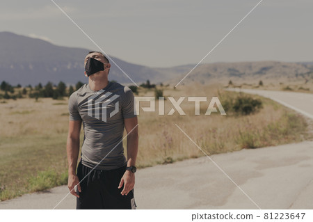 Young man and woman in protective masks running and doing exercises outdoors in the morning. Sport, Active life Jogging during quarantine. Covid-19 new normal. High quality photo. Selective focus. Young man and woman in protective masks running and doing exercises outdoors in the morning. Sport, Active life Jogging during quarantine. Covid-19 new normal. High quality photo. Selective focus. 81223647