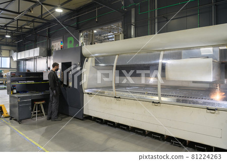 A smart factory worker or engineer wears a face mask because of a pandemic and makes machines in a production workshop. The concept of industry and engineering. 81224263