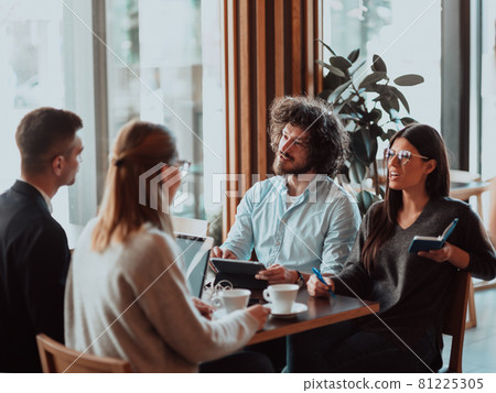 a group of young entrepreneurs on a coffee break discuss the project while using modern editing tablets, a smartphone and a laptop.Business concept 81225305