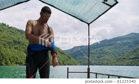 triathlon athlete getting ready for swimming training on lake triathlon athlete getting ready for swimming training on lake 81225340
