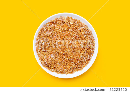 Fried minced garlic recipe in white plate on yellow background. 81225520