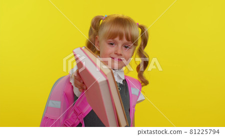 Pretty positive kid primary school girl with ponytails wearing uniform smiling on yellow background Pretty positive kid primary school girl with ponytails wearing uniform smiling on yellow background 81225794