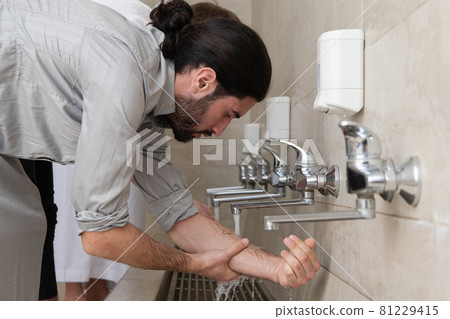 a group of Muslims take ablution for prayer. Islamic religious rite 81229415