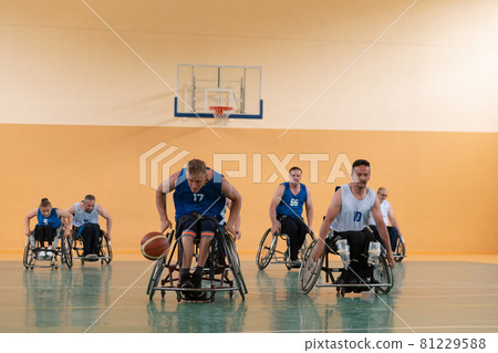 disabled war veterans in action while playing basketball on a basketball court with professional sports equipment for the disabled 81229588