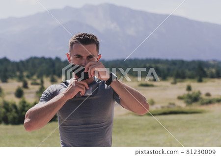 Young man and woman in protective masks running and doing exercises outdoors in the morning. Sport, Active life Jogging during quarantine. Covid-19 new normal. High quality photo. Selective focus. Young man and woman in protective masks running and doing exercises outdoors in the morning. Sport, Active life Jogging during quarantine. Covid-19 new normal. High quality photo. Selective focus. 81230009