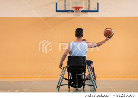 a photo of a war veteran playing basketball with a team in a modern sports arena. The concept of sport for people with disabilities a photo of a war veteran playing basketball with a team in a modern sports arena. The concept of sport for people with disabilities 81230166