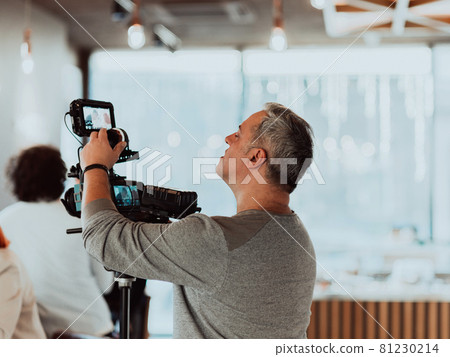 Cameraman working on professional camera taking stock footage Cameraman working on professional camera taking stock footage 81230214
