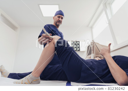 doctor working at the hospital operating ultrasound scanning machine examining knee of her female patient technology modern medicine people vitality concept. doctor working at the hospital operating ultrasound scanning machine examining knee of her female patient technology modern medicine people vitality concept. 81230242