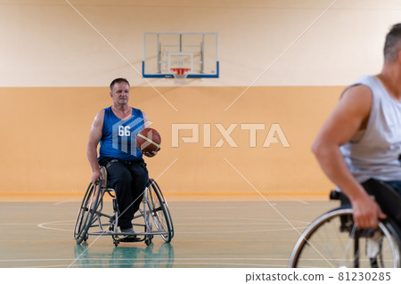 disabled war veterans in action while playing basketball on a basketball court with professional sports equipment for the disabled disabled war veterans in action while playing basketball on a basketball court with professional sports equipment for the disabled 81230285
