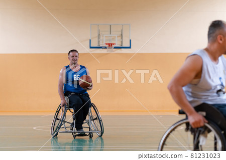 disabled war veterans in action while playing basketball on a basketball court with professional sports equipment for the disabled 81231023
