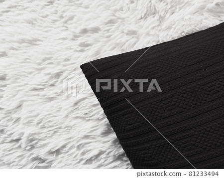 Black cushion throw pillow on white fluffy plaid blanket as flat lay background, bedroom top view and home decor Black cushion throw pillow on white fluffy plaid blanket as flat lay background, bedroom top view and home decor 81233494