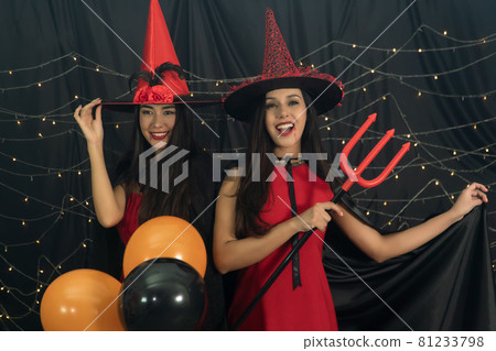 fun two young women wear red dress witch Halloween 81233798