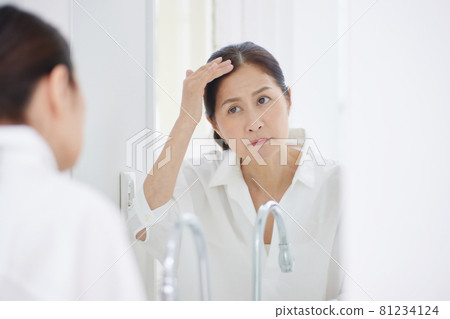 關心頭髮的資深婦女 關心頭髮的資深婦女 81234124