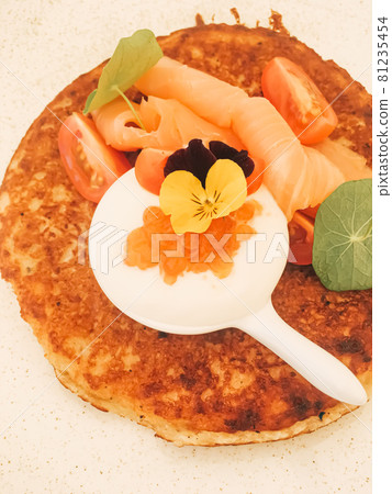 Potato fritter pancake with red caviar, salmon and sour cream in luxury restaurant outdoors in summer 81235454