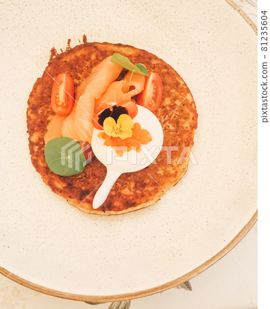 Potato fritter pancake with red caviar, salmon and sour cream in luxury restaurant outdoors in summer 81235604