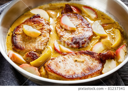 pork chops in apple cider cream sauce in a pan 81237341