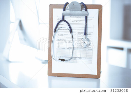 Stethoscope and clipboard with medication history records are on the table at the doctor's working place. Medicine and health care concept Stethoscope and clipboard with medication history records are on the table at the doctor's working place. Medicine and health care concept 81238038