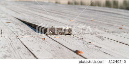 Close-up of a wooden floor with a sticking out board. Close-up of a wooden floor with a sticking out board. 81240540