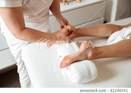 Young woman having foot massage procedure in spa salon 81240541