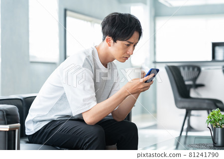 Men's living room smartphone lifestyle Men's living room smartphone lifestyle 81241790