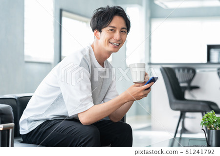 Men's living room smartphone lifestyle Men's living room smartphone lifestyle 81241792